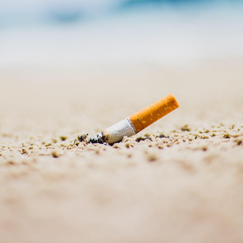 A cigarette discarded on a beach