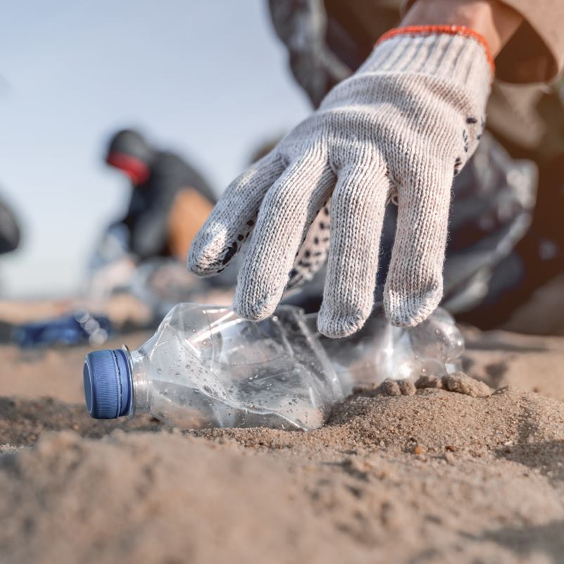 Volunteer collecting plastic garbage on the beach