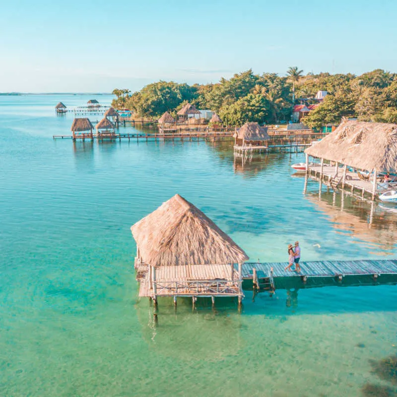 overwater bungalows in bacalar with colorful wter