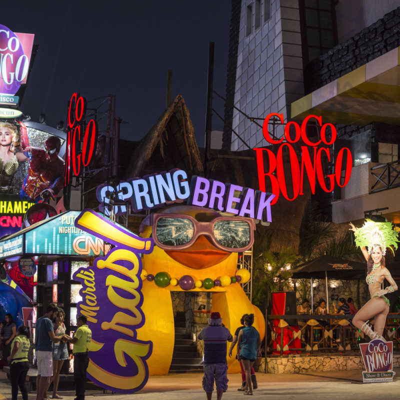 a busy party district in cancun with neon lights 