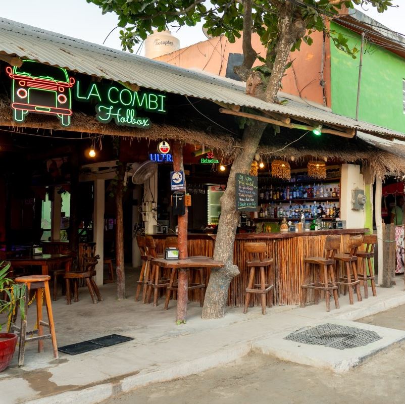 A shot of a bar restaurant and a golf cart taxi on a sandy street, Holbox, Mexico