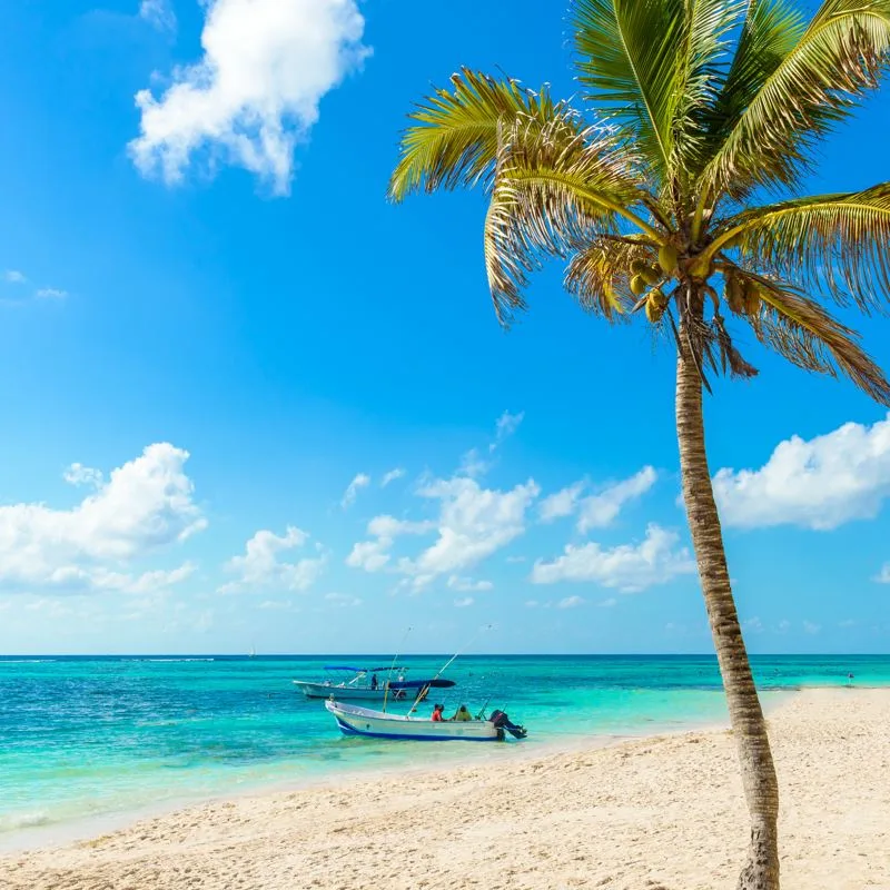 A beach at akumal in the Riviera Maya with small fishing boats in shot