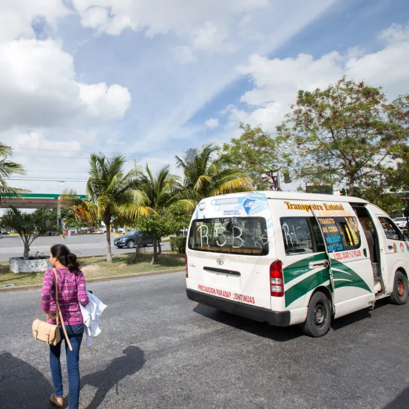 Tourist Walking Behind a Taxi Van in Downtown Cancun, Mexico