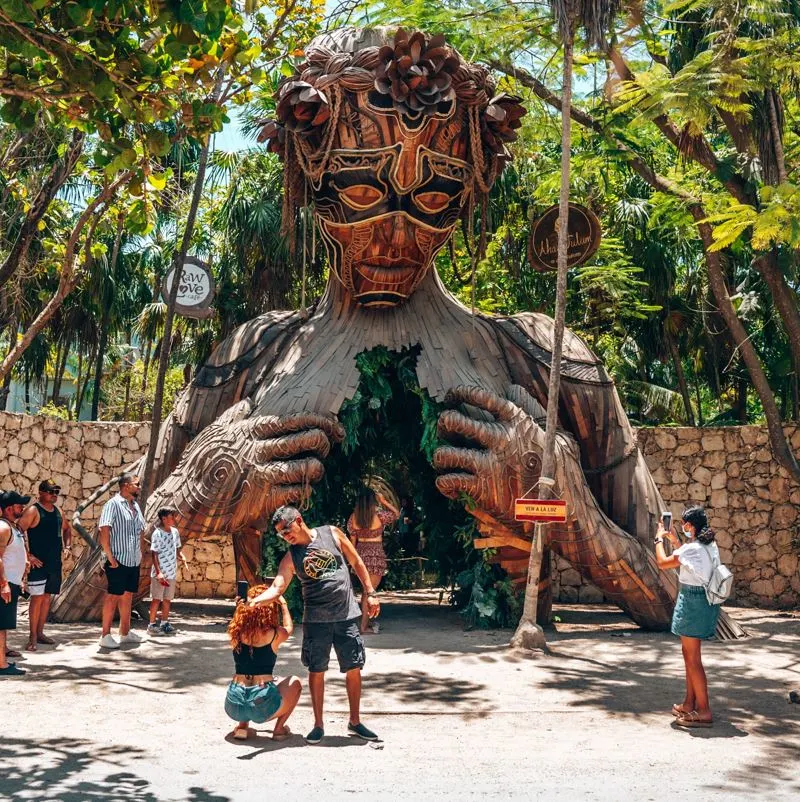 Tulum tourists taking picture of sculpture 