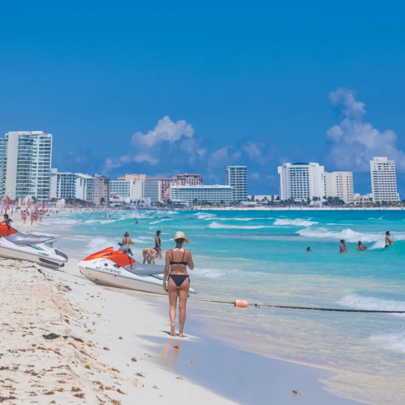 Mujer caminando por la playa de Cancún