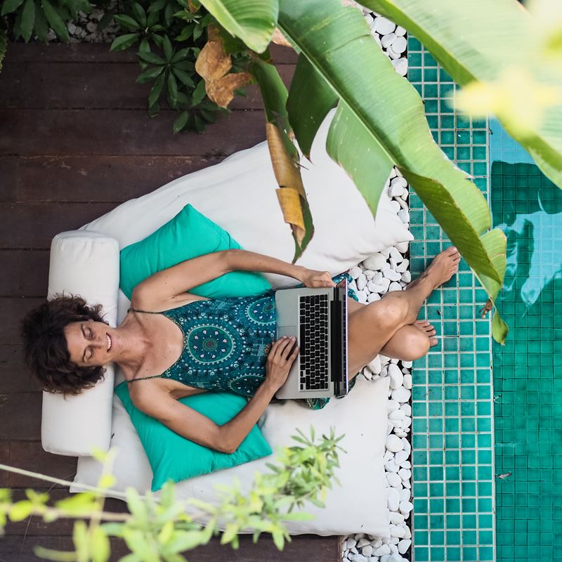 Woman with laptop by the pool