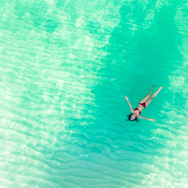 tourist floating in clear blue sea in cancun