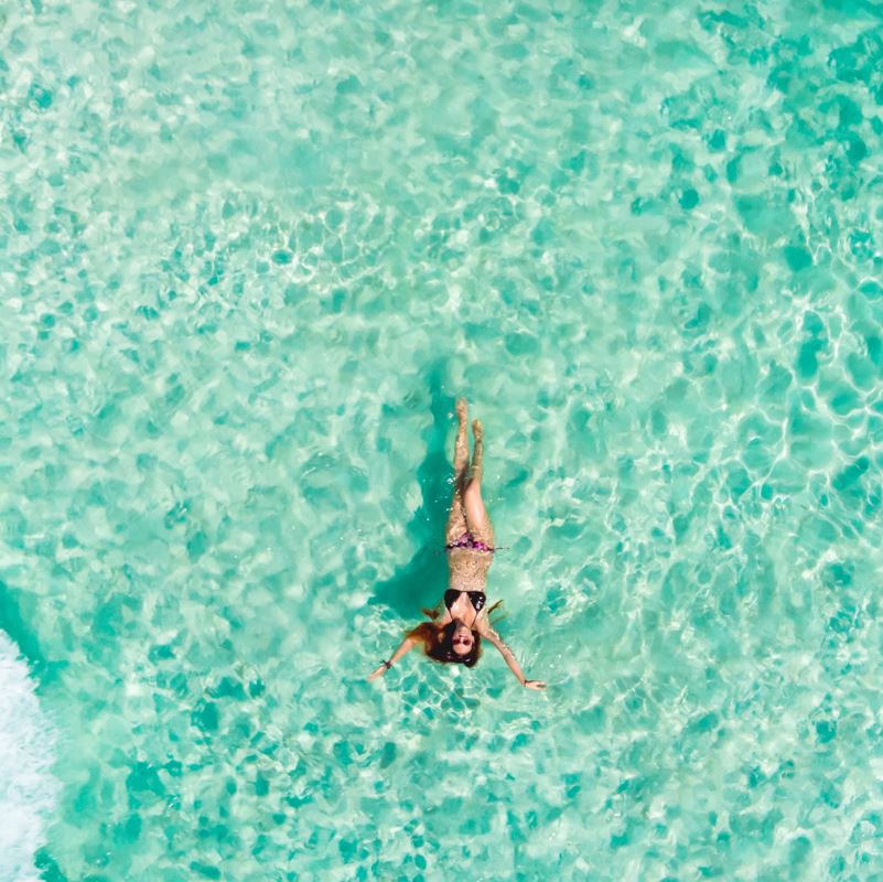 tourist floating in crystal clear waters in Mexican Caribbean
