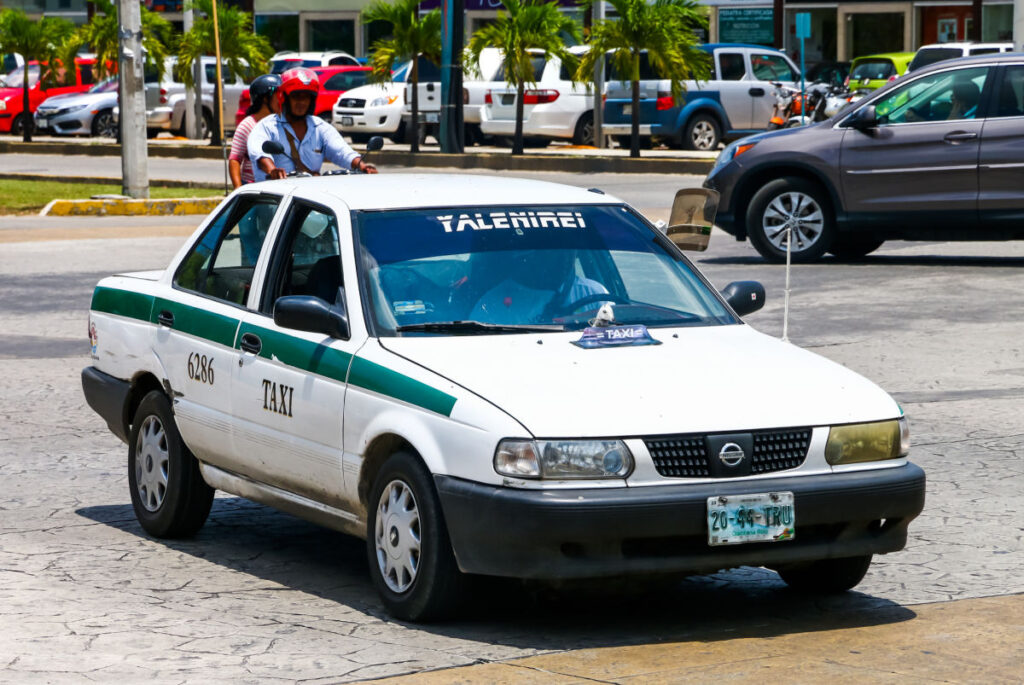 Rundown Cancun Taxi Driving Down the Street 