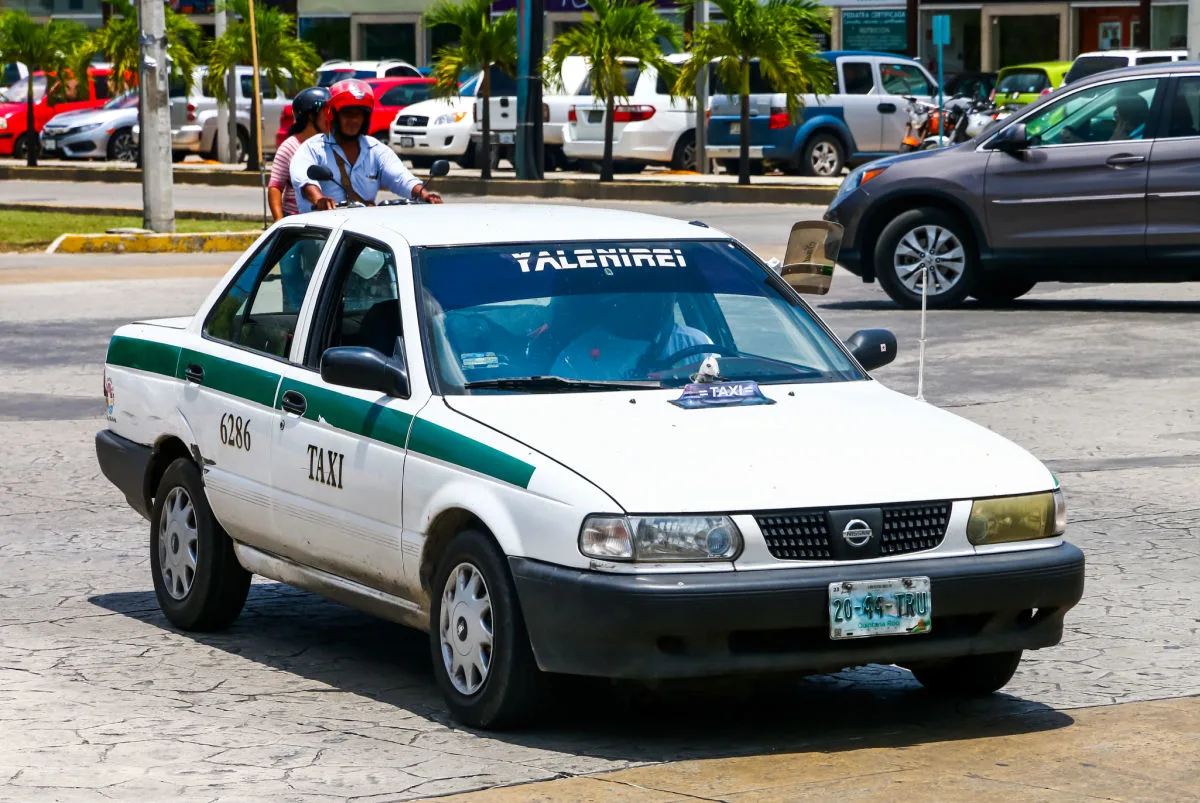 Rundown Cancun Taxi Driving Down the Street