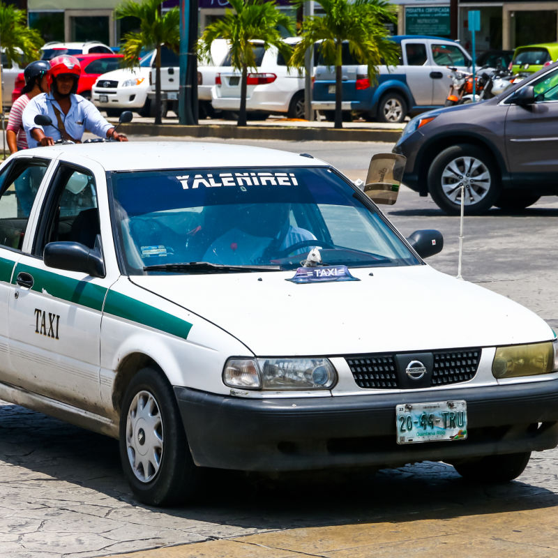 Rundown Cancun Taxi Driving Down the Street