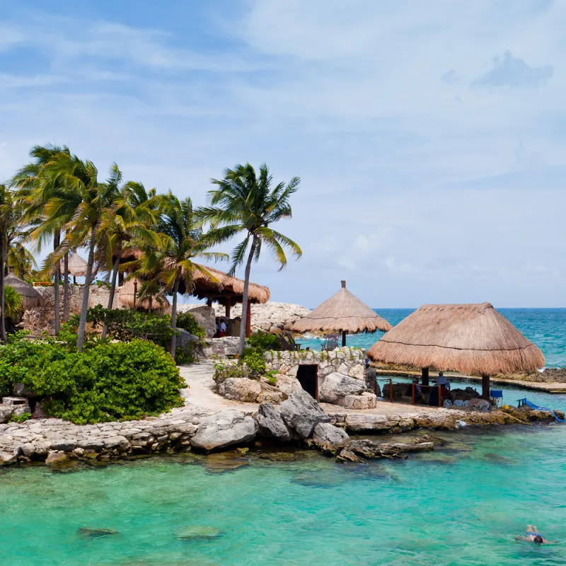 beach cove with tourist floating in the water in the mexican caribbean