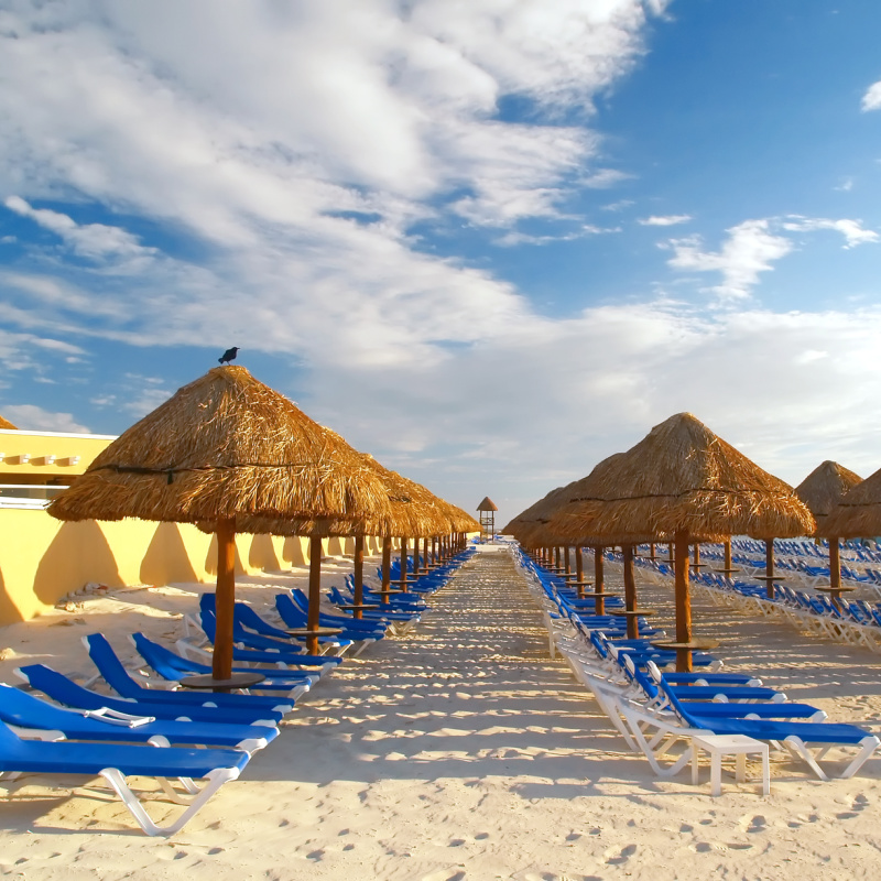beach sun loungers and parasols in cancun