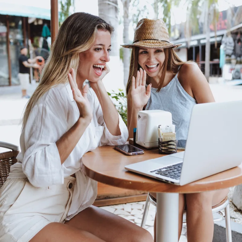 two female digital nomads on laptop in a coffee spot in the Mexican Caribbean