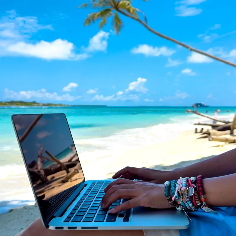 Digital nomad with laptop at the beach