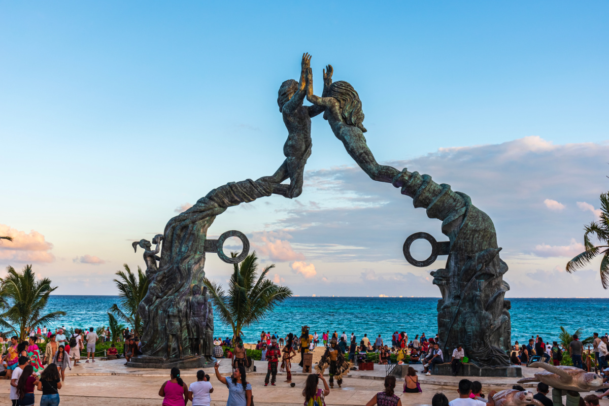 famous playa del carmen statue on beach with busy tourists
