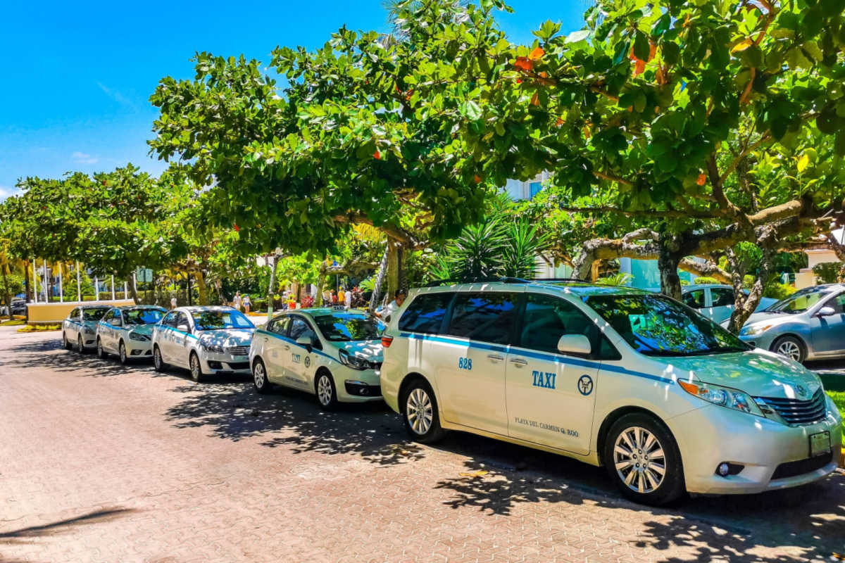 several taxis lined up on the street in cancun 
