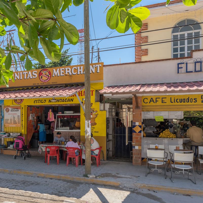 A taco shop and cafe on a street in Tulum
