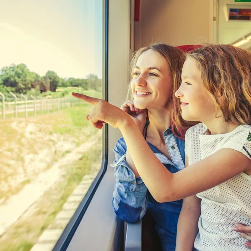 Little girl with his mother on a train looking out the window