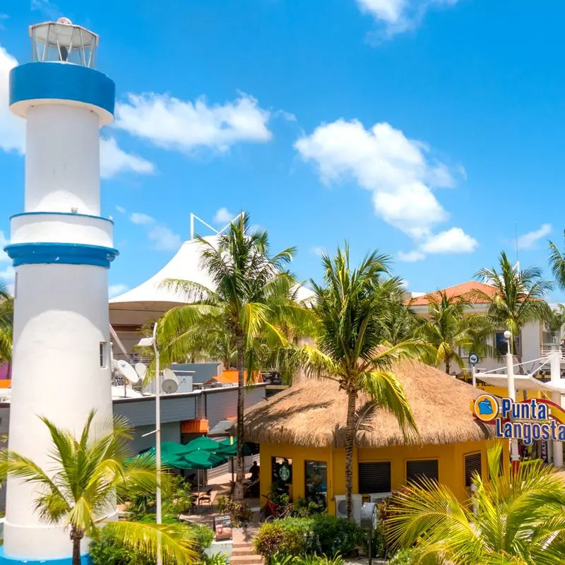 Punta Langosta Cozumel, with palm trees, shopping mall and lighthouse