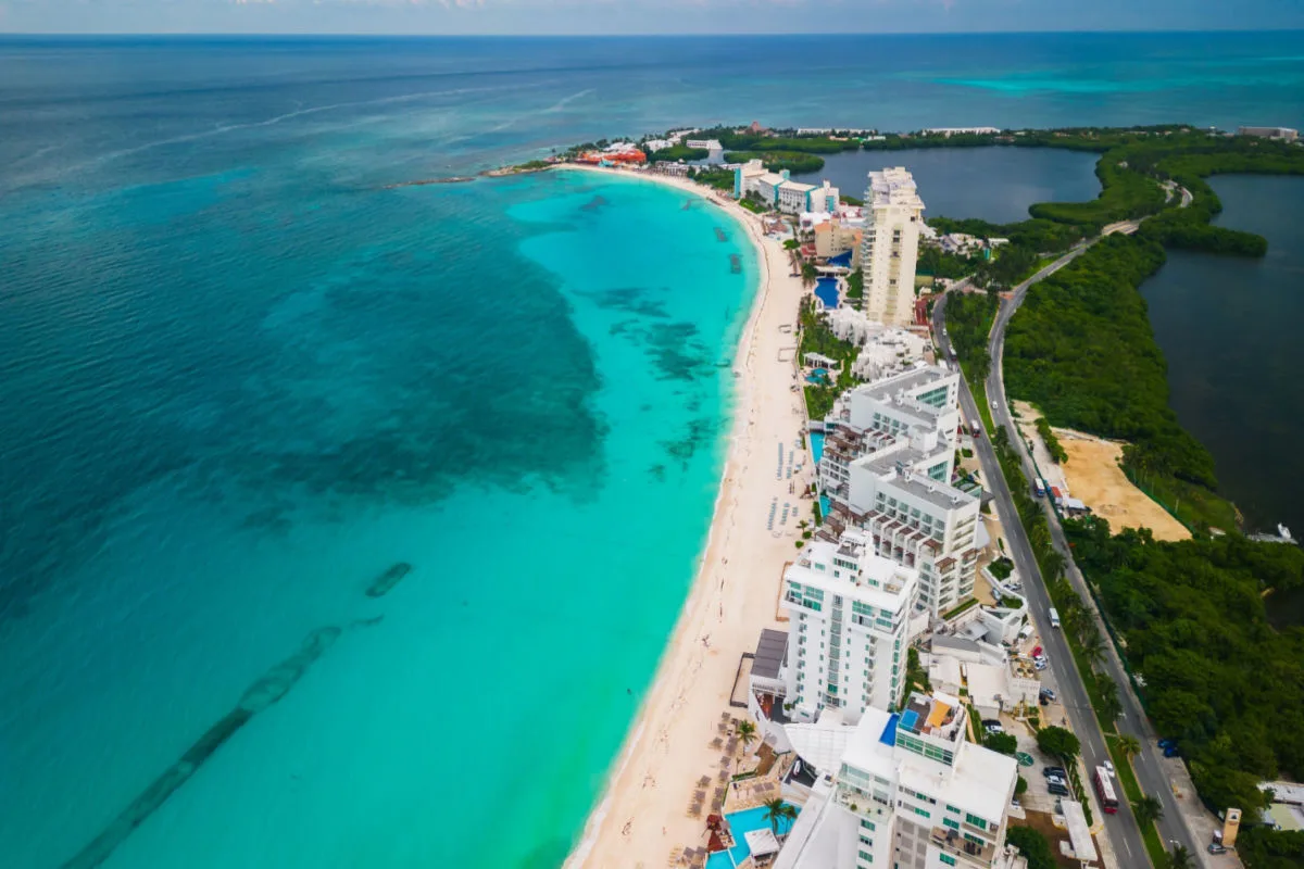 aerial view of a white sand beach in cancun with resorts