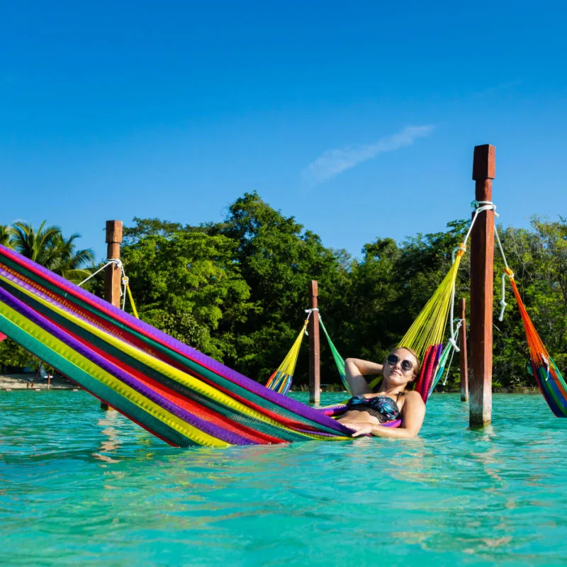Female Tourist Lounging in a Hammock in the Bacalar Lagoon in Bacalar, Mexico