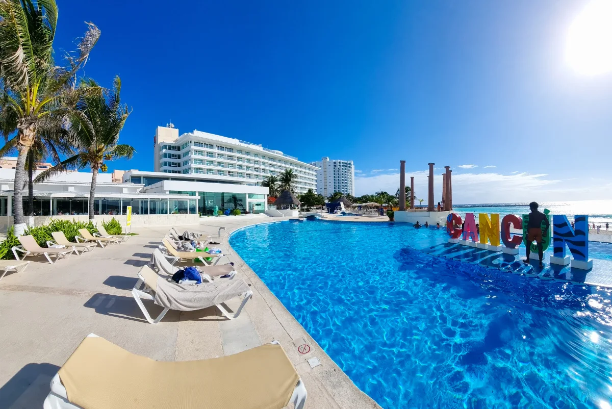 Tourist in Front of a Cancun Sign in a Beautiful Resort Pool