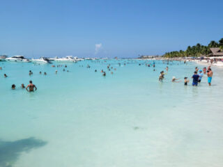 Tourists and Boats in the Water at a Beach in Isla Mujeres, Mexico