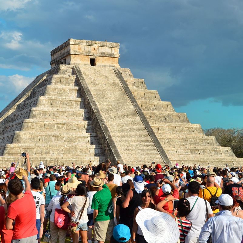 A busy and crowded view of travelers at chichen itza