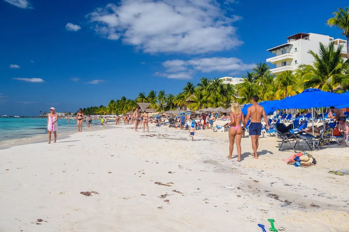 Isla Mujeres tourists walking on the beach on a sunny day