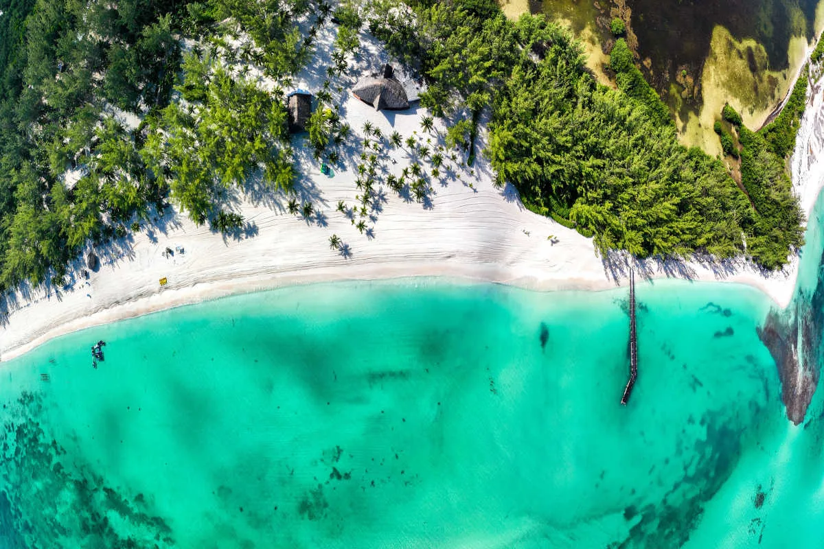 aerial view of a white sand beach in cozumel with blue water