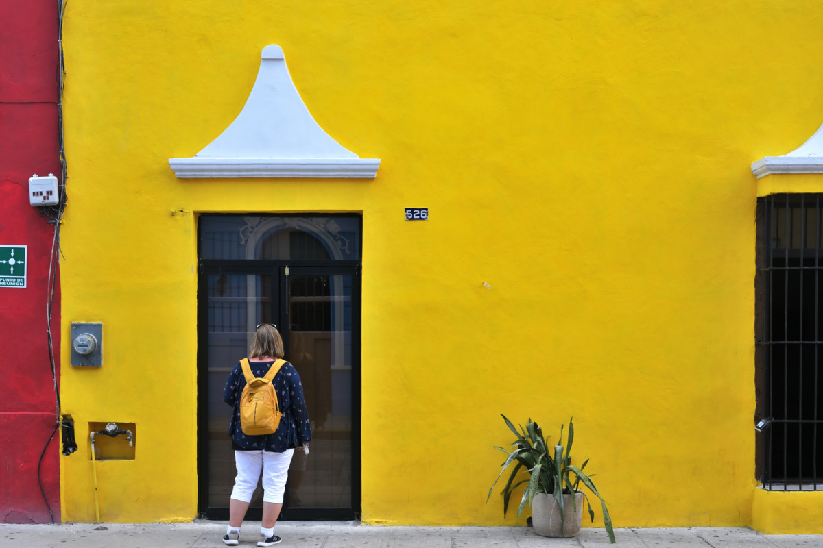 tourist admiring painted walls in Merida