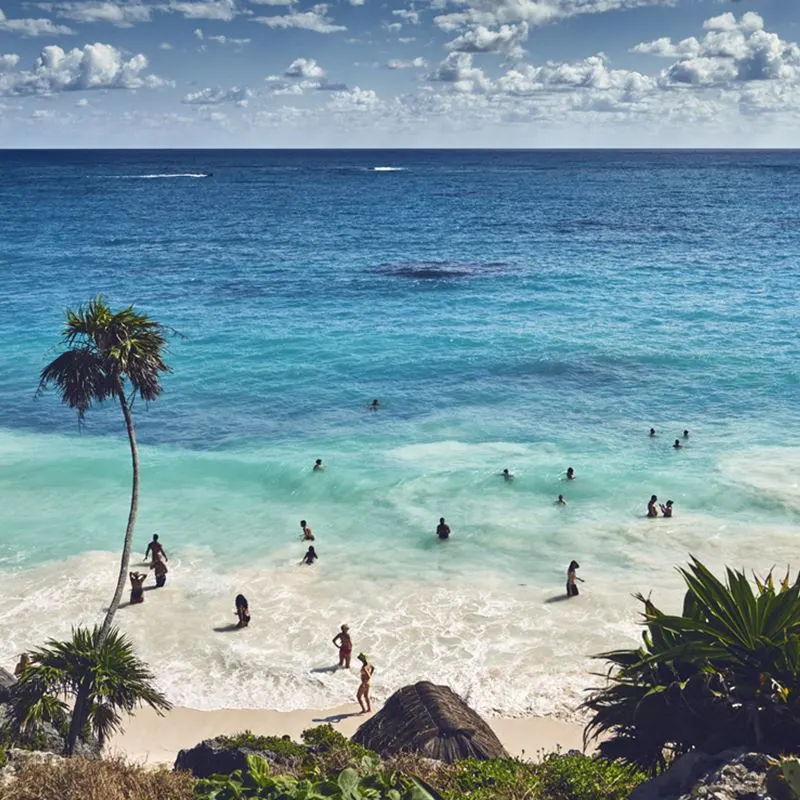 Tourists enjoying Tulum's beaches on a sunny day