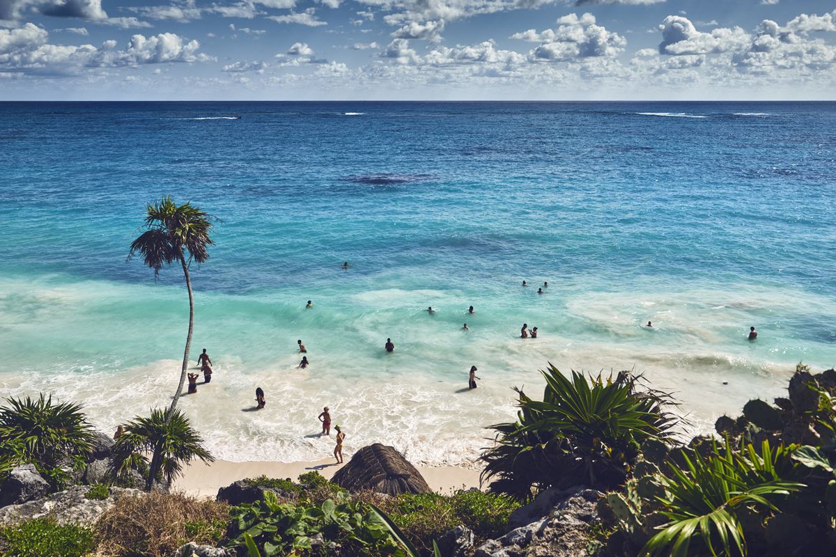Tourists enjoying Tulum's beaches on a sunny day
