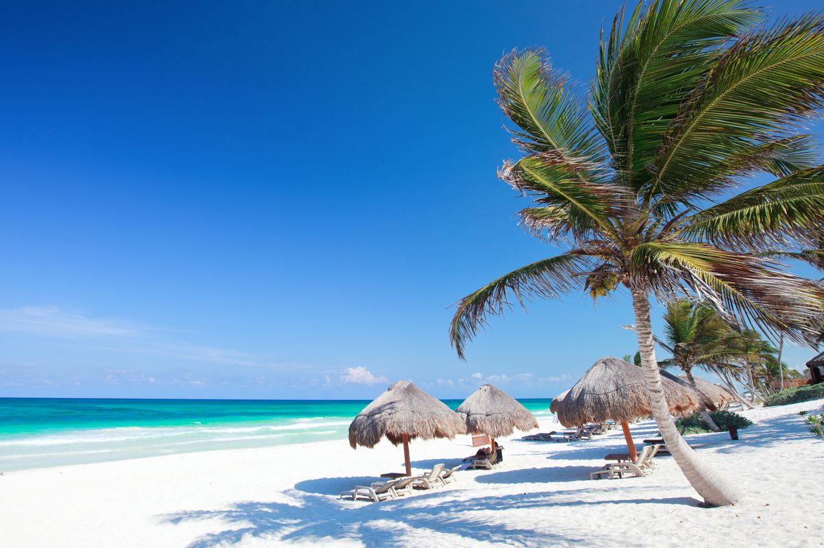A tulum beach on a sunny day with calm waters and clear skies