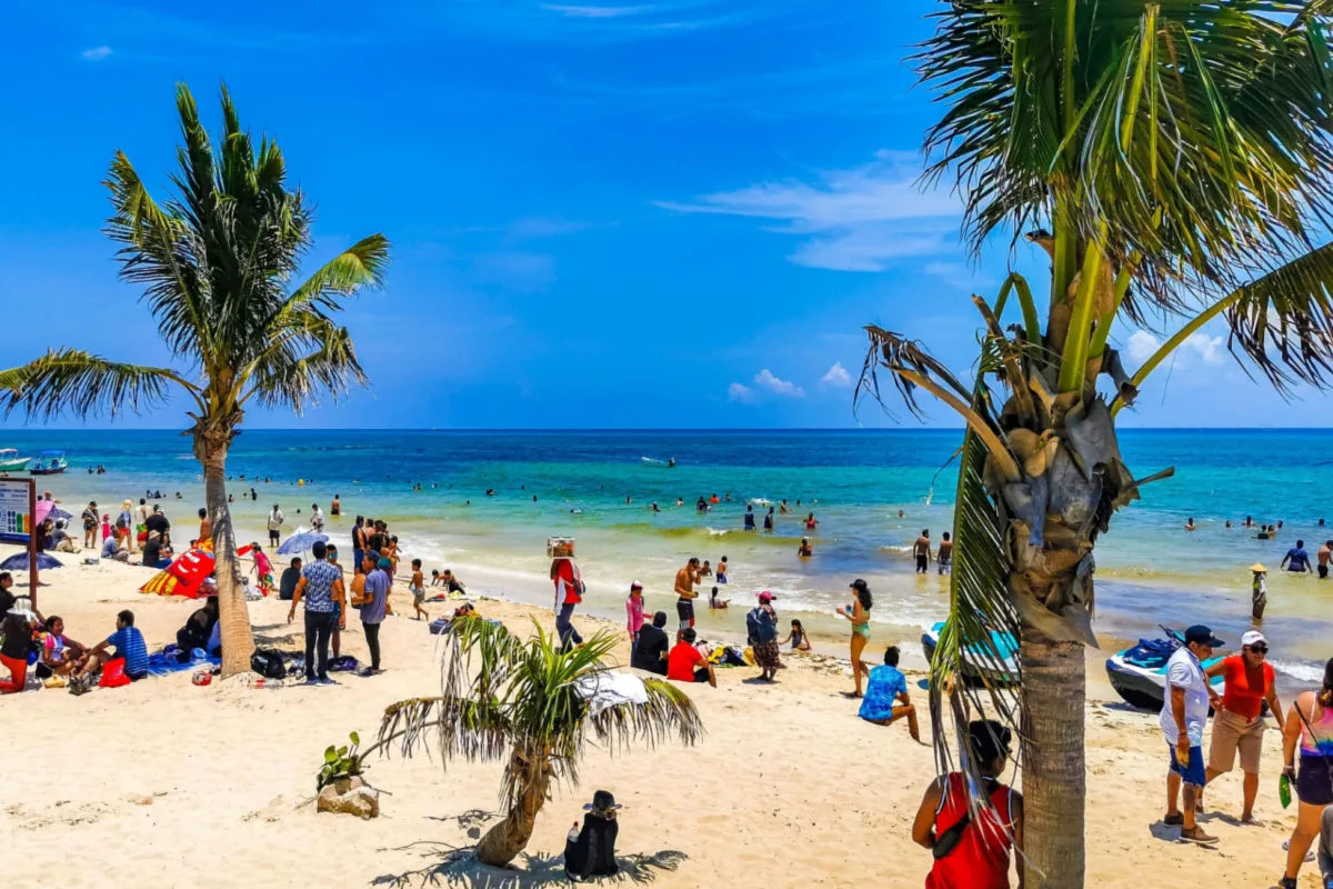a large white sand beach in playa del carmen with travelers