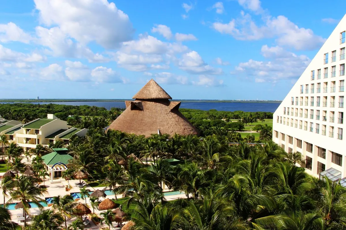 View from the balcony on the hotel resort with palm trees, pools and the lagoon in the background, Cancun