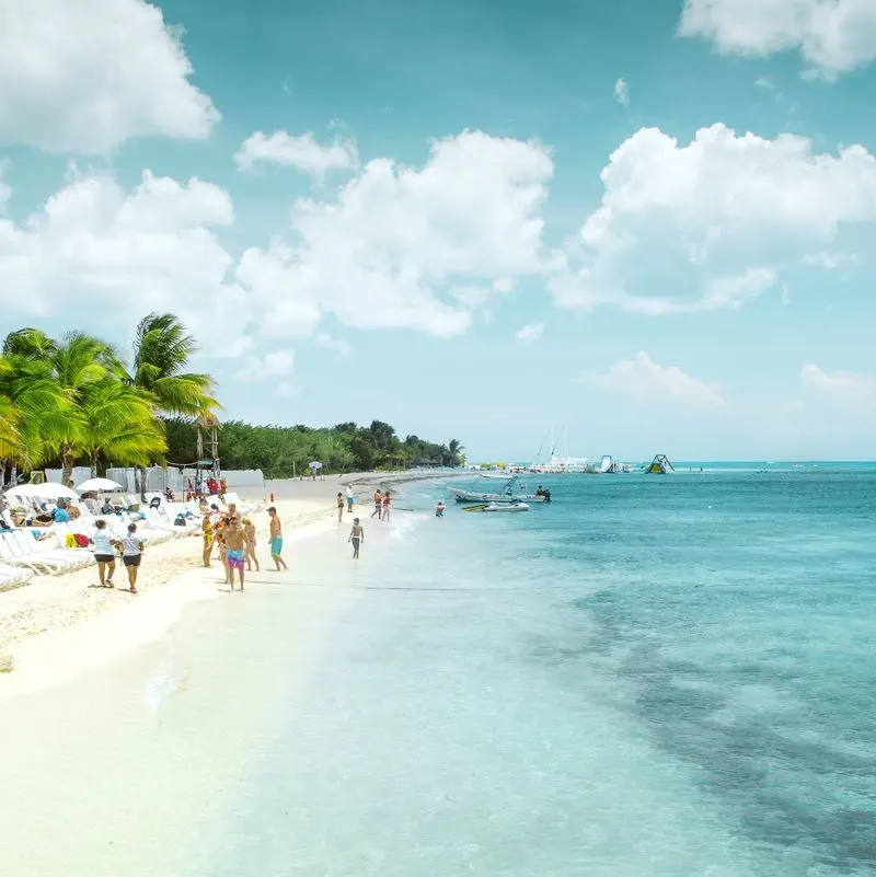 a cozumel beach with tourists on a sunny day