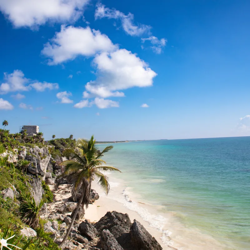beach destination in Tulum with Mayan Ruins above on clifftop