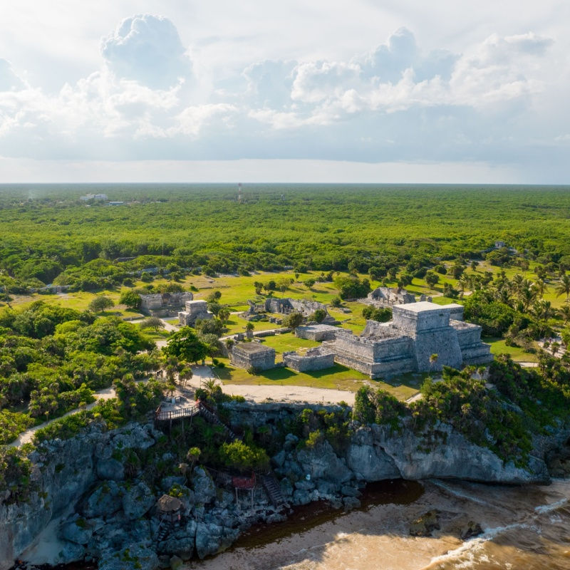 aerial view of the mayan site in tulum with green forests
