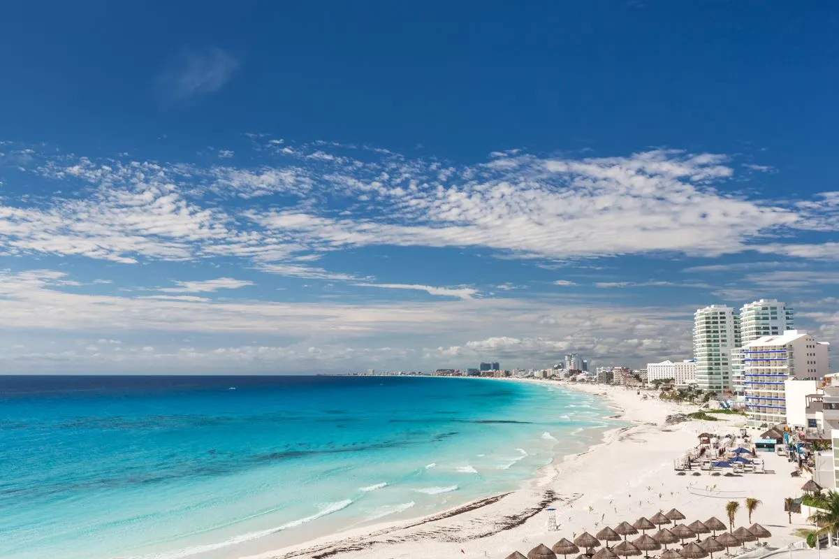 a panoramic views of the cancun hotel zone beach with multiple resorts in view