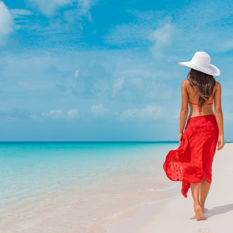 a young female traveler walking on the beach in cancun 