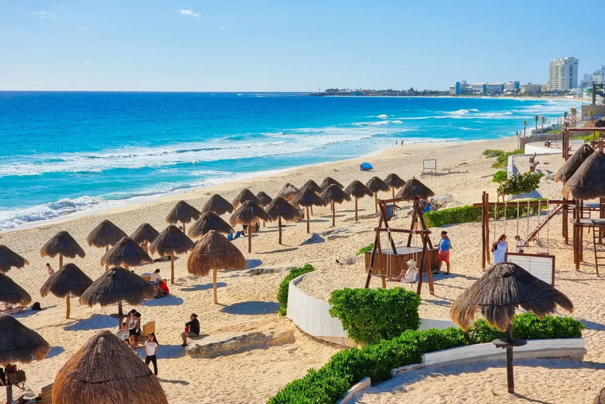 Tourists and Palapas on a Beach in Cancun, Mexico
