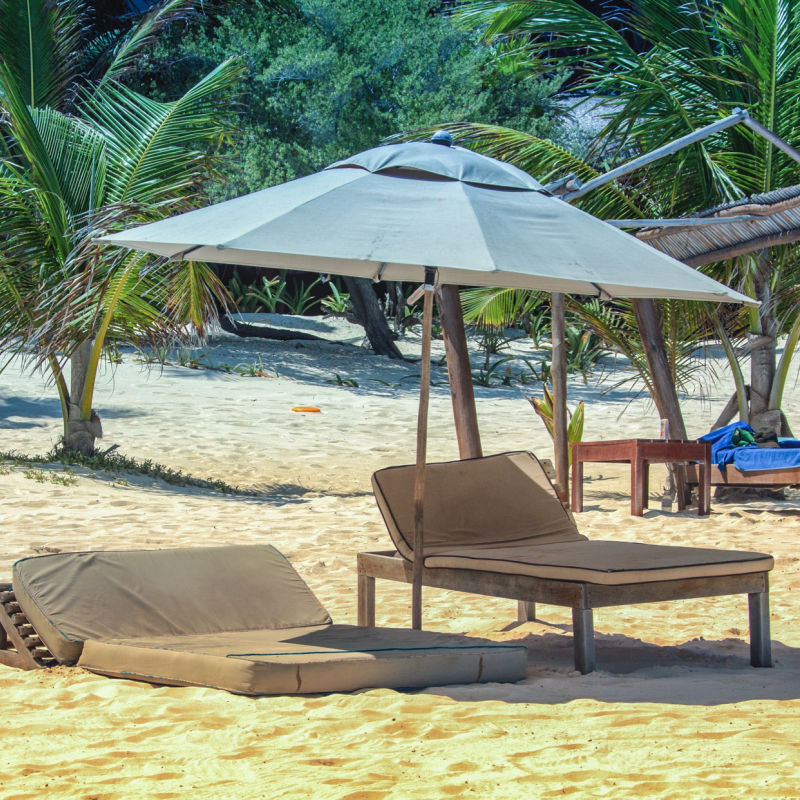 sun lounger and umbrella on golden sandy beach in Tulum