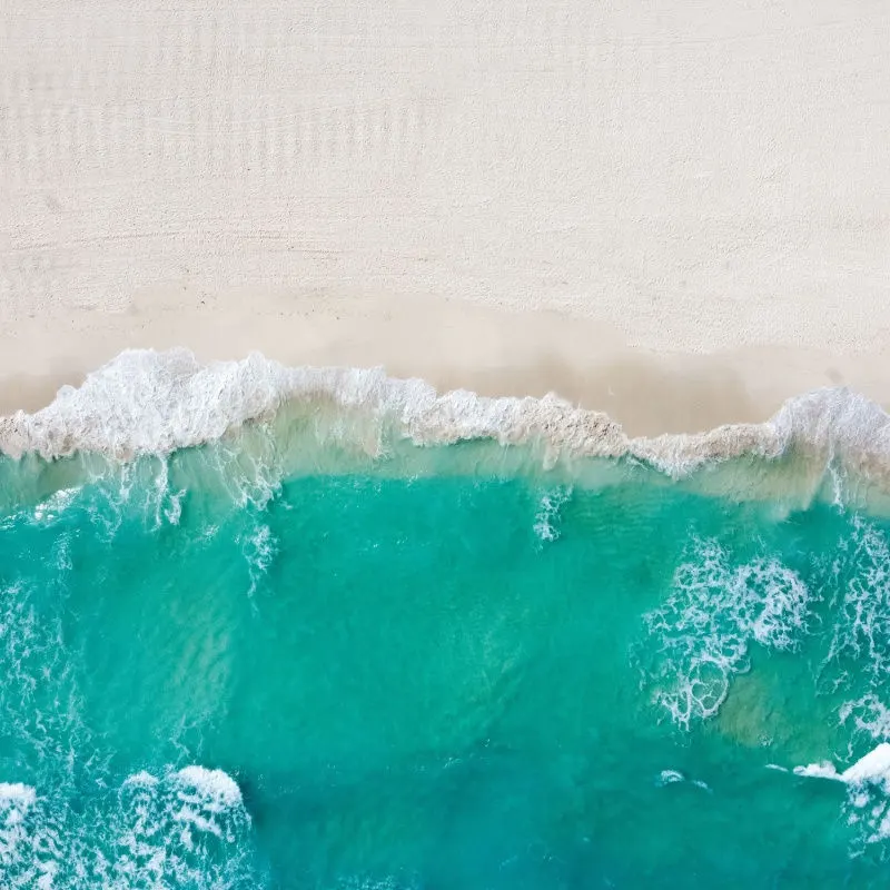 aerial view of a white sand beach with water in cancun 