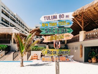 Wood sign at sandy Cancun beach resort