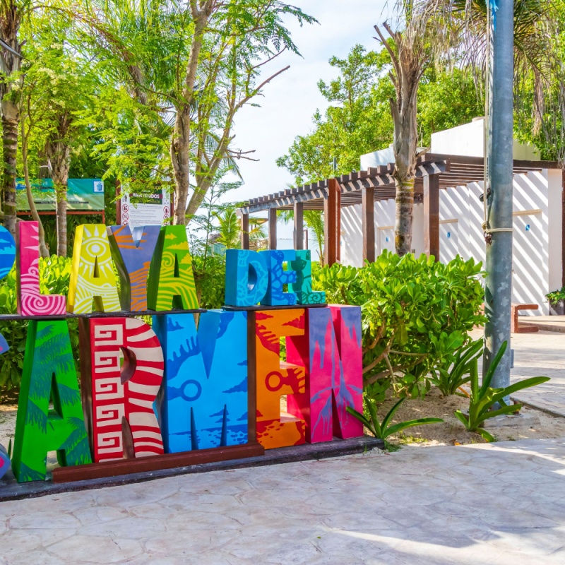 a colorful playa del carmen sign on beach