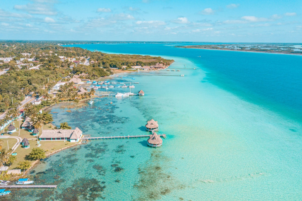 a bacalar beach aerial with overwater bungalows