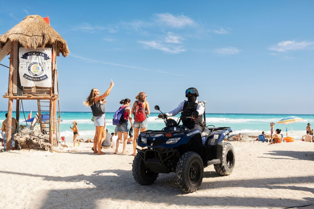 quad police on a popular cancun beach with travelers 