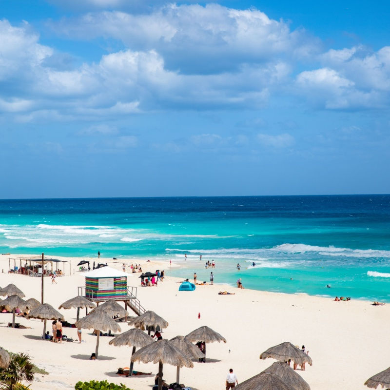 sunny day on a cancun beach with travelers